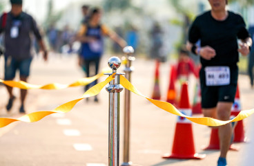 luxury stainless barricade with yellow rope ribbon on the road in Marathon event at the finish...