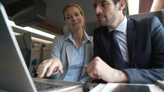 two colleagues working on a train