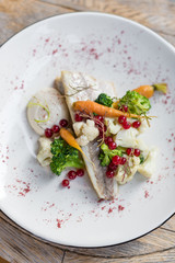Poached White Fish with Steamed Vegetables and Garlic Aioli Sauce. Top View.