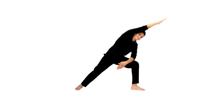 Full-length shot of male energetic young teenager isolated on white background doing waist twisting exercise by bending on one side with one hand stretched out in air. Male active pose. Active pose.