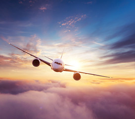 Fototapeta premium Commercial airplane flying over dramatic sunset