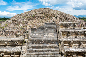Architectural details of the walls of  significant Mesoamerican pyramids and green grassland located at at Teotihuacan, an ancient Mesoamerican city located in a sub-valley of the Valley of Mexico