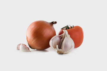 Ajo, cebolla y tomate juntos sobre fondo blanco