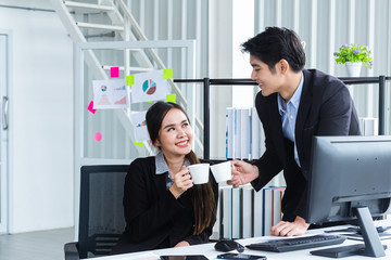 Businesswoman and Businessman Asian people hold a white coffee mug with a smile