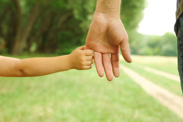  parent holds the hand of a small child
