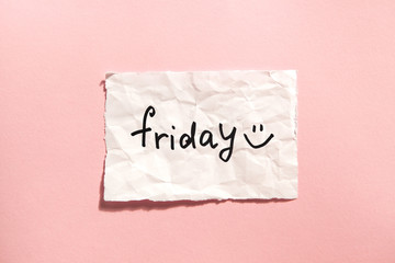 Friday - word with happy face smile on pink background, weekends after work concept