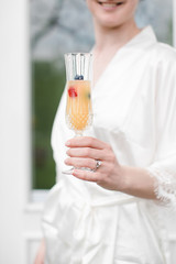bride holding drink in hand on wedding morning - 299128487