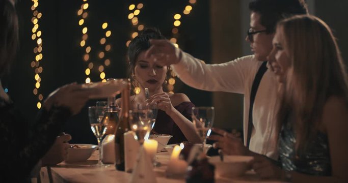 Multiracial young mans and womans wearing fashion wear clinking glasses with champagne, happy asian american and caucasian friends celebrating xmas, new year or birthday party indoors