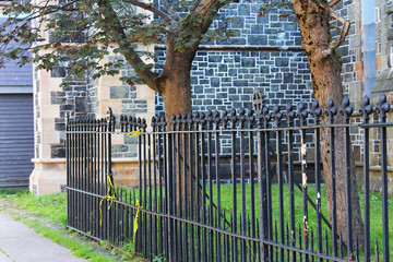 Iron fence with a broken section around the church yard of the Cathedral of St. John the Baptist, St. John's, Newfoundland, Canada