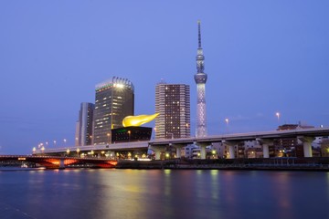 Tokyo sky tree with Asahi beer tower near Sumida river before sunset in Japan 