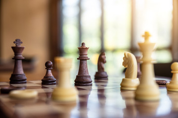 Wooden chess on a chessboard in morning