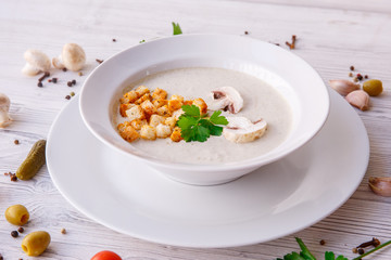 mushroom cream soup on a light wooden background