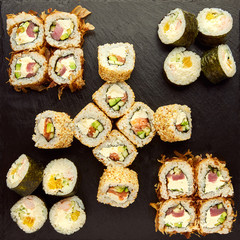 Various kinds of tasty sushi roll  isolated on black stone background for menu. Japanese food