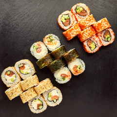 Various kinds of tasty sushi roll  isolated on black stone background for menu. Japanese food