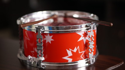 The rattle is a musical instrument played by children.Red drum for kid on black background concept