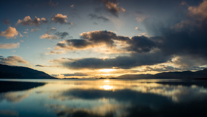 loch linnhe in the argyll region of the highlands of scotland during an autumn sunset showing golden light on the clouds and water and the islands of lismore and shuna