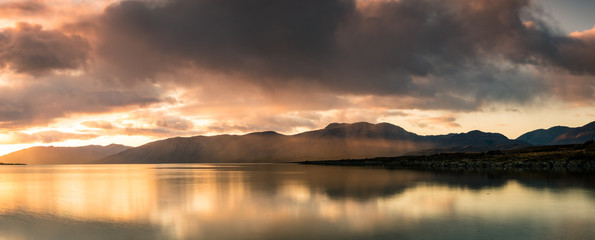 Fototapeta na wymiar loch linnhe in the argyll region of the highlands of scotland during an autumn sunset showing golden light on the clouds and water and the islands of lismore and shuna