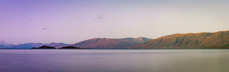 loch linnhe in the argyll region of the highlands of scotland during an autumn sunset showing golden light on the clouds and water and the islands of lismore and shuna