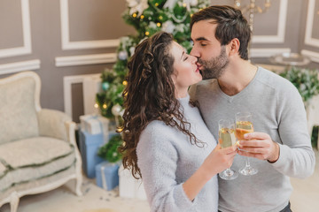 Shot of cool man and woman making wishes, with glasses of champange in their hands.