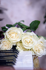 A bouquet of flowers on the piano keys. A bouquet of roses on a musical instrument.