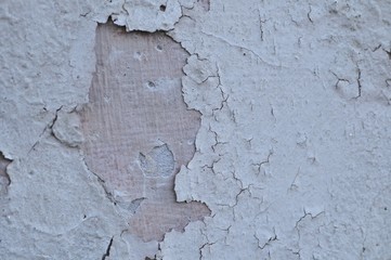 Cracked Broken Destroyed Weathered Plaster Paint on the Exterior White Wall