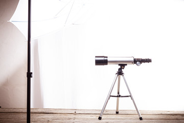 telescope on a white background laid on wooden board