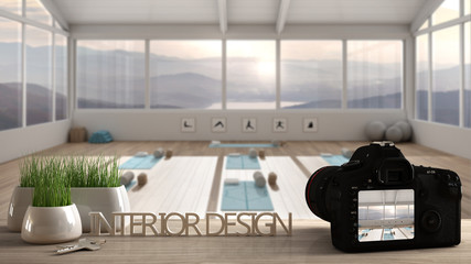 Architect photographer designer desktop concept, camera on wooden work desk with screen showing interior design project, empty yoga studio interior design with mats, meditation room