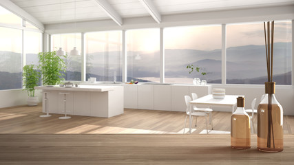 Wooden table top or shelf with aromatic sticks bottles over blurred modern kitchen with island, white architecture interior design