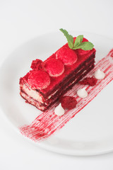 Plate with piece of delicious red velvet cake on white background