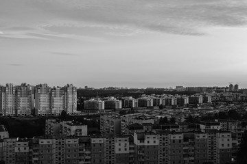 Panorama of a new standing area. The contrast of new and old houses. Black and white photo with soft contrast. Drama