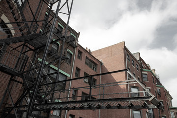 Cantilevered fire escape on rear of an old city apartment building, horizontal aspect