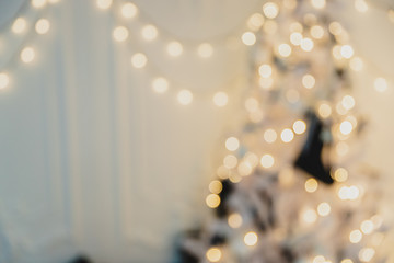 Gold defocused christmas garland and fir with baubles and ribbons on white.