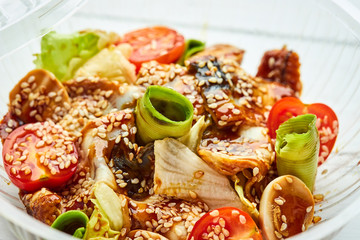 Tasty salad with smoked eel, avocado and tomato. Healthy food concept