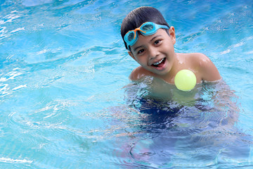 Cute boy on summer vacation swimming pool having fun and happy time. Activities on the pool.