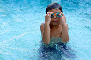Naklejka premium Cute boy wearing goggles ready to swim.