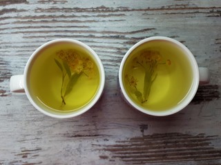  close-up of two cups of hot aromatic linden-colored tea