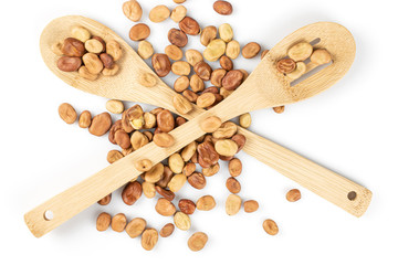 Lot of whole fresh brown bean vicia faba with two crossed spoons isolated on white background