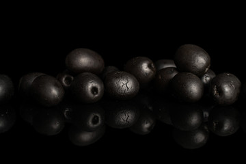 Lot of whole canned black olive isolated on black glass