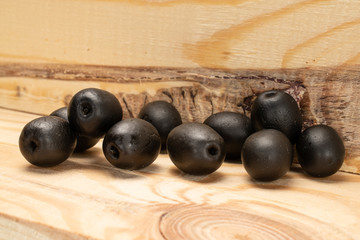 Lot of whole canned black olive on wooden stand