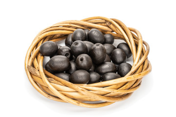 Lot of whole canned black olive with wicker ring made of twigs isolated on white background