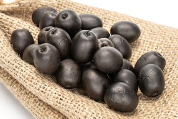 Lot of whole canned black olive with jute bag isolated on white background