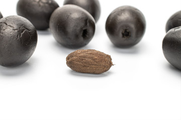 Lot of whole one piece of canned black olive with olive stone isolated on white background