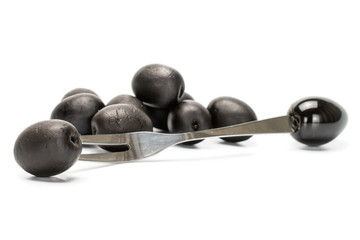 Lot of whole canned black olive with olive fork isolated on white background