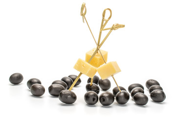 Lot of whole canned black olive with bamboo skewer and piece of cheese isolated on white background