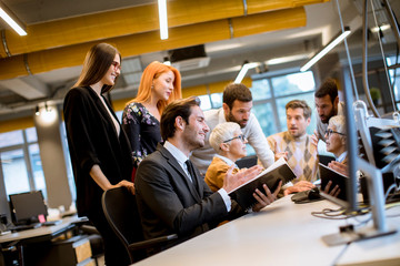 Senior businesswoman working together with young business people in office