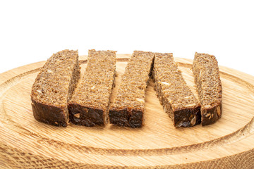 Group of five pieces of fresh baked dark bread on bamboo plate isolated on white background