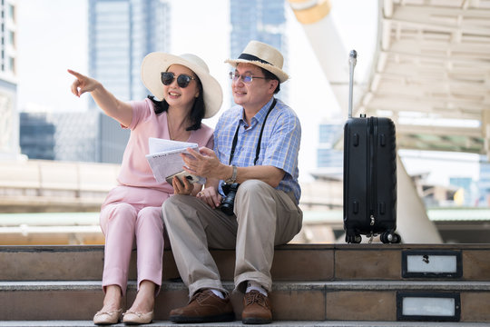 Travel ideas of couples in retirement life, couple of travelers using map for sightseeing in town.