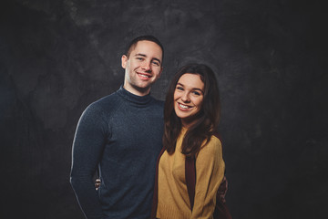 Charming happy couple is posing for photographer at photo studio.
