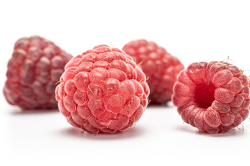 Group of five whole fresh crimson raspberry isolated on white background
