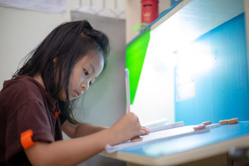 Young asian girl doing his homework